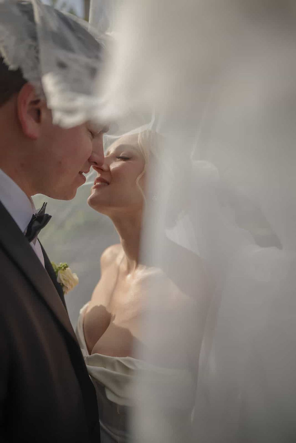 Cinematic wedding portrait of a couple sharing an intimate moment beneath a veil at Casa Loma