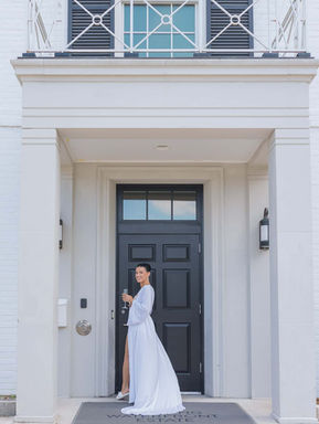 Bride standing in the entrance of a classic white mansion