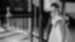 Black and white candid wedding photo of a couple from behind, walking up a sunlit, modern staircase at a contemporary Toronto venue.