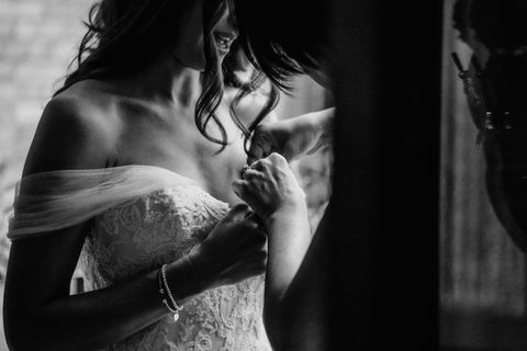 Candid full-length shot of the bride adjusting her veil and dress in a hallway during Toronto wedding preparations.