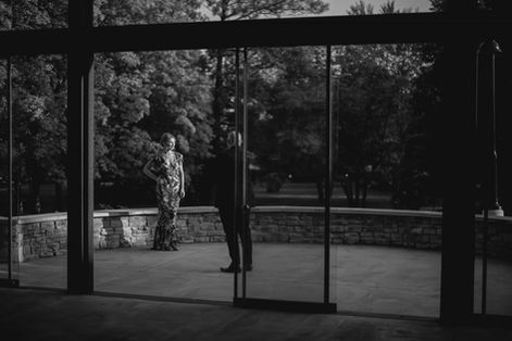 Bride looking pensively through an architectural frame at Guild Inn Estate, captured in black and white by a Scarborough wedding photographer