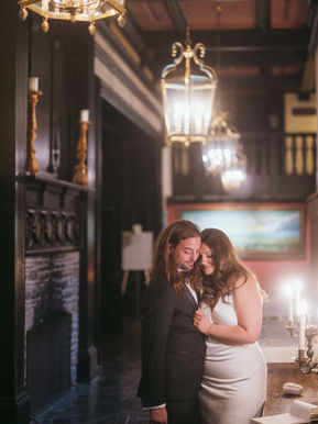 Romantic couple portrait in the stone foyer of Old Mill Toronto illuminated by hanging vintage lanterns