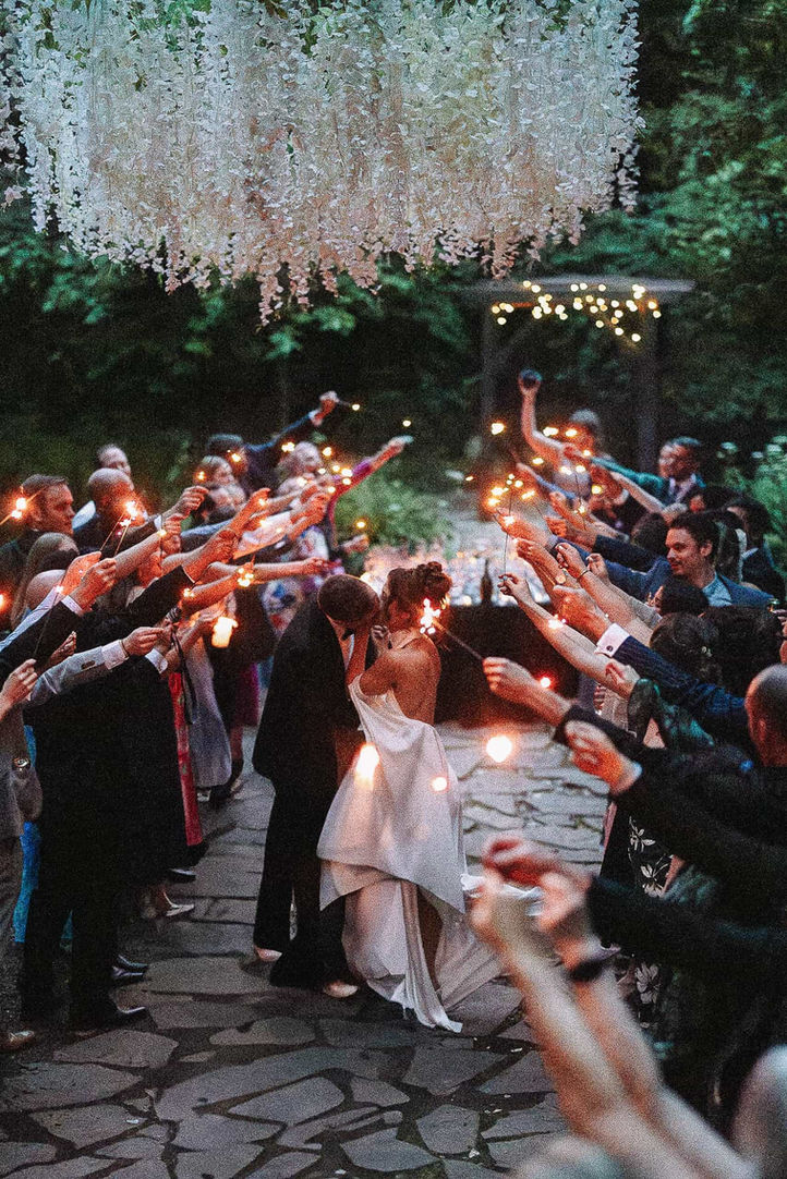 Bride and groom run through guests holding sparklers during their Toronto wedding reception exit