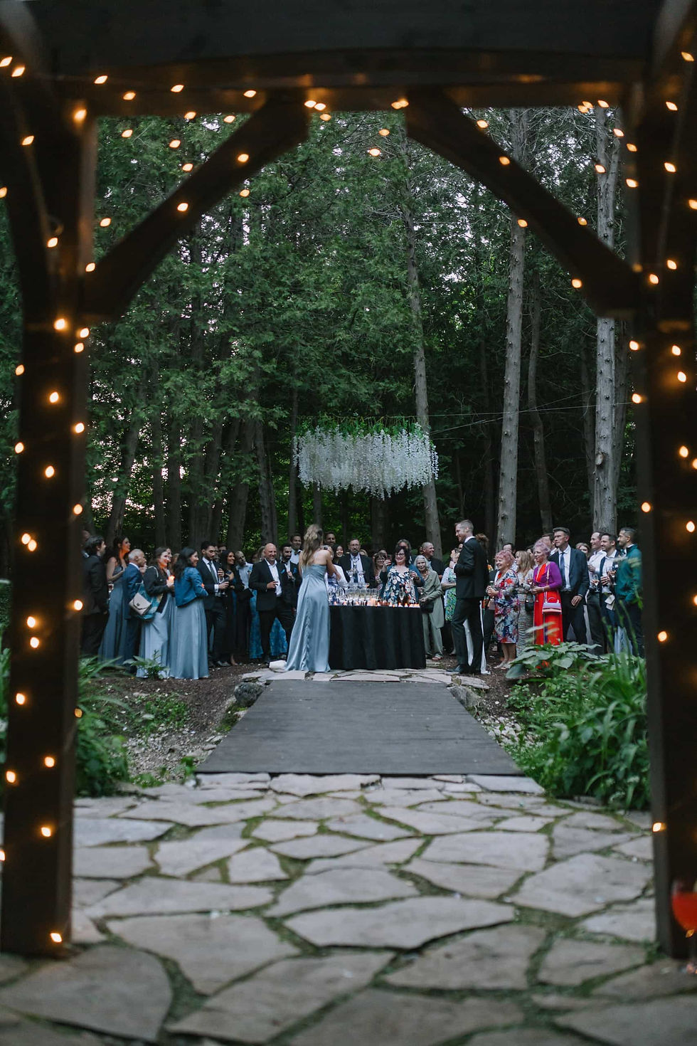 An outdoor woodland wedding ceremony under twinkling string lights at Erin Estate.