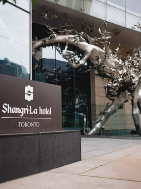 The iconic "Rising" metallic sculpture by Zhang Huan in front of the Shangri-La Hotel Toronto signage, a popular spot for urban wedding portraits