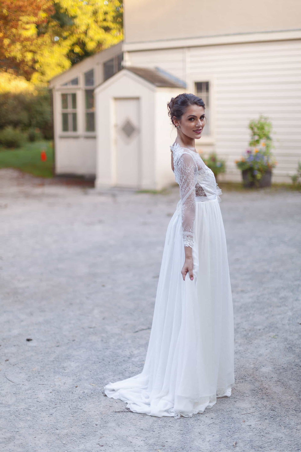 Bright outdoor bridal portrait of a smiling blonde bride with wavy hair wearing an off-the-shoulder lace wedding dress at High park