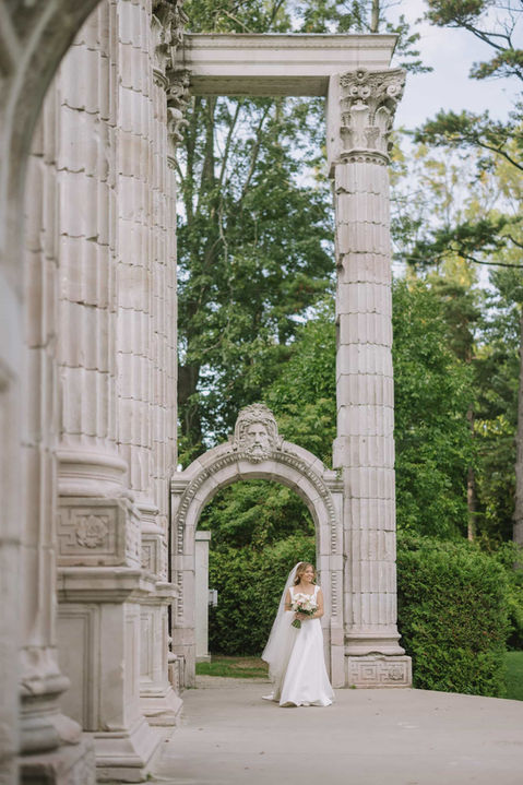 A couple sharing a quiet moment beneath a historic stone archway, showcasing the architectural textures of the Guild ruins.