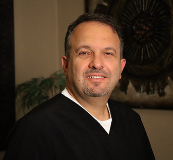 Dr. Haddad, a dental professional in Lancaster, smiling at the camera.