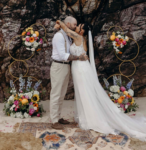 Burleigh Beach Micro-Wedding Gold Coast. Couples first kiss surrounded by colourful flowers and bouquet. Ceremonies by Sacha.