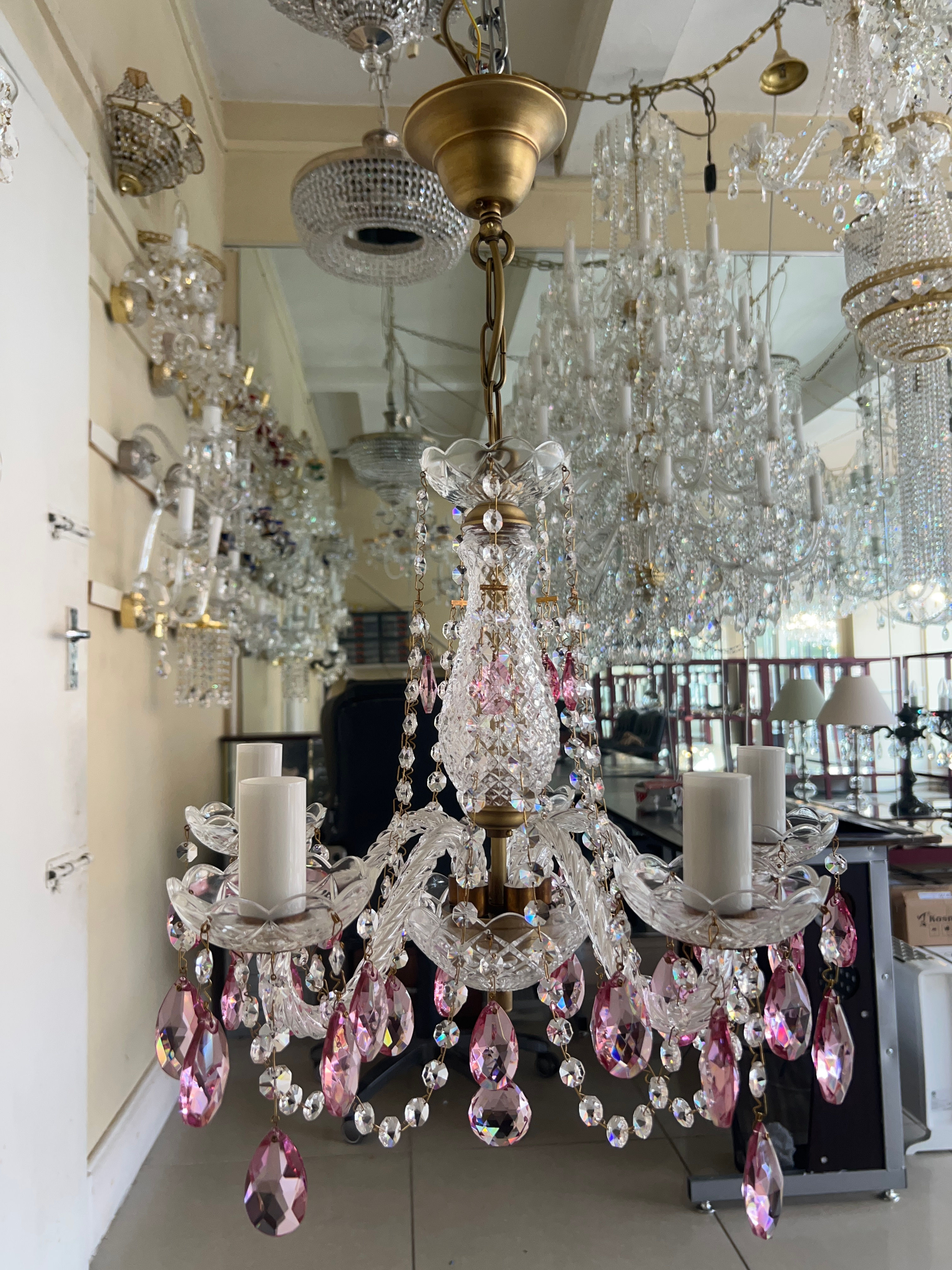 Farrah5-1001LP. Coloured chandelier in a light patina finish, with pastel pink oval-shaped lead crystals and crystal chains.