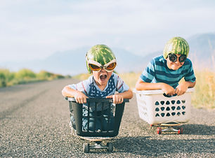 Young Boys Racing Wearing Watermelon Helmets