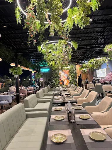 Outdoor rooftop dining lounge with greenery and modern hospitality design