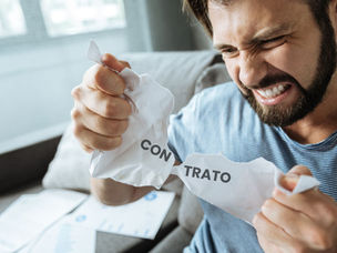 Homem, com semblante irritado, rasgando um papel em que está escrita a palavra contrato, indicando o rompimento da relação contratual com perdas e danos.