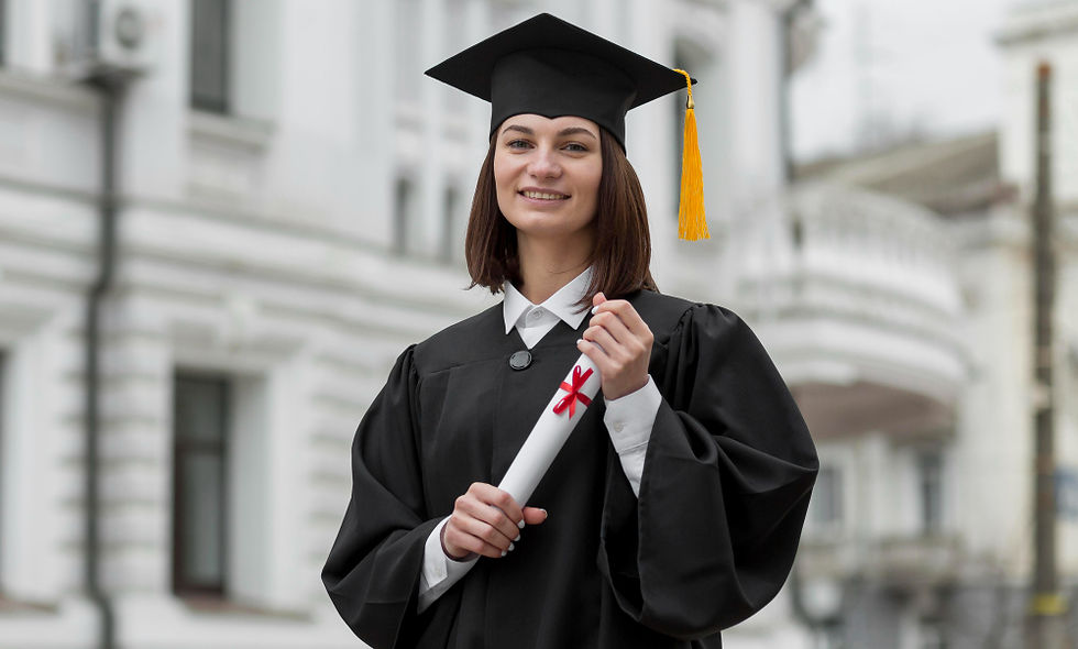 A graduate stands proudly in her cap and gown, holding her diploma with a smile, against the backdrop of an elegant, historic building.