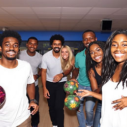 A group of people smiling and holding bowling balls