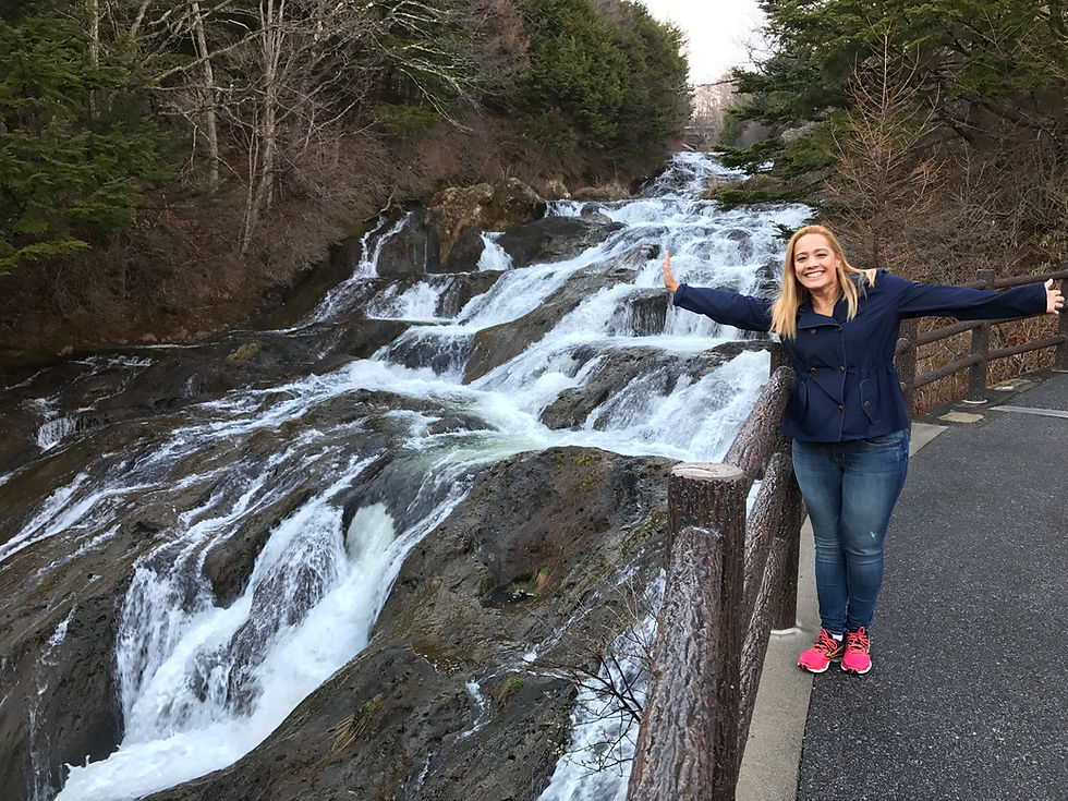 uma moça em frente a uma catarata