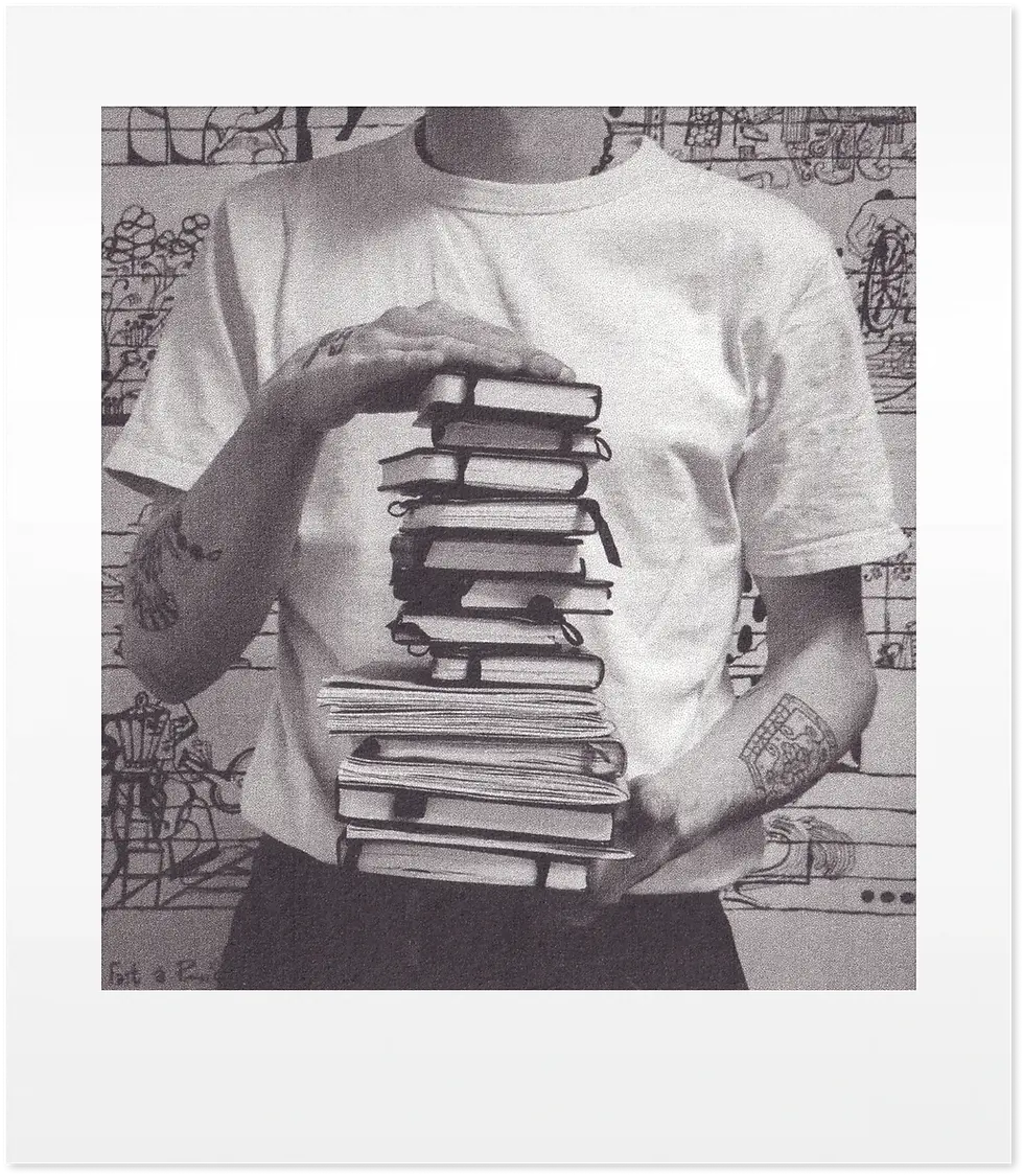 corentin tenant une pile de carnets de dessins