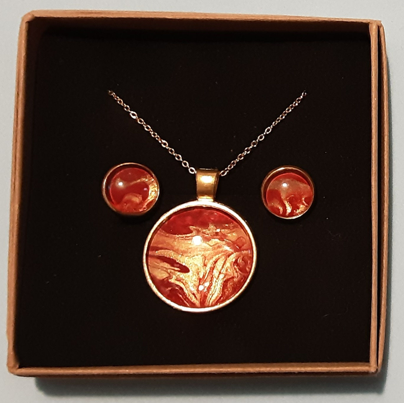 Gold coloured pendant set in red and gold
