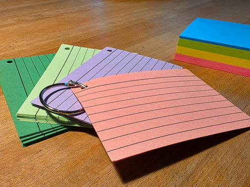 Kleine verschiedenfarbige Karteikarten mit Loch und Ring sowie mehrfarbige Post-It zum systematischen Eintragen von Passwörtern