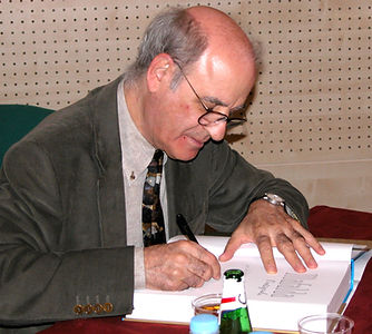 Quino_(cartoonist)_autographs_a_book_in_