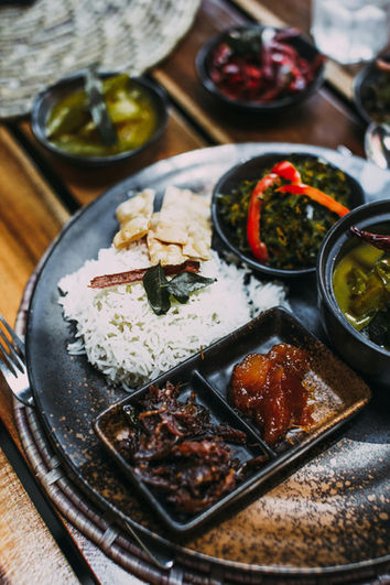Traditional Sri Lankan rice and curry served on a metal plate during an authentic local dining experience.