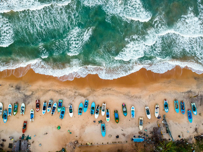 Aerial view of Arugam Bay beach with surfboards lined along the shore during Sri Lanka's east coast surf season