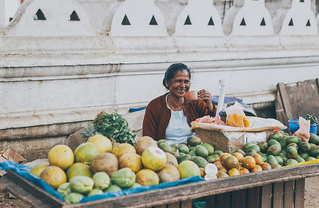 Local fruit vendor smiling at a traditional market in Sri Lanka