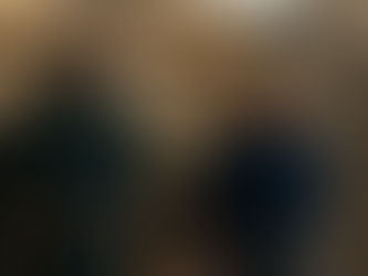 Two men in superhero suits stand confidently in front of a gold, star-patterned wall. One wears green, the other blue. Serious mood. With Prime Video symbol.