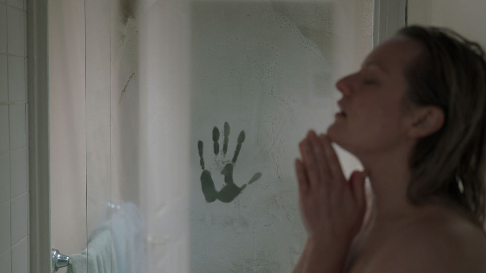 Woman in a steamy shower, hands clasped in prayer beside a handprint on the glass, in a dim bathroom.