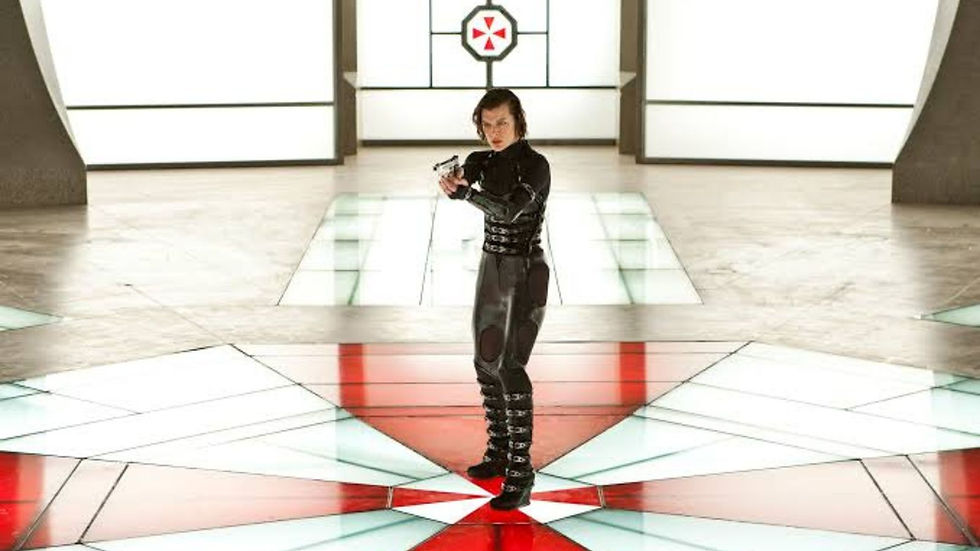 Woman in black tactical suit aims a gun in a bright sci-fi hall with a red Umbrella logo on the back wall.