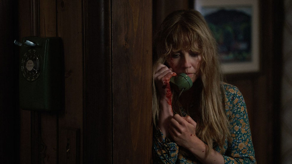Crystal Lake (2026): Linda Cardellini as Pamela Vorhees on the phone with a bloody hand in Crystal Lake.