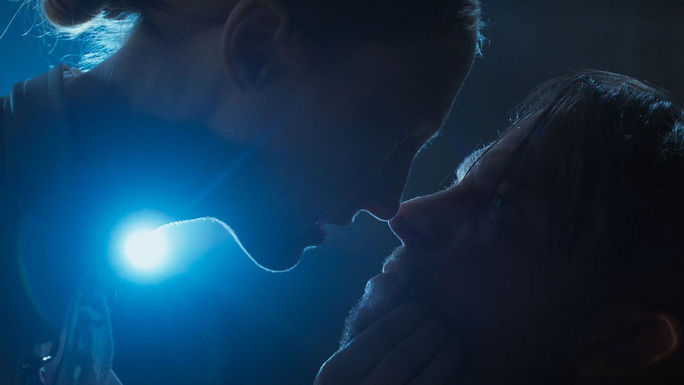 Close-up of two people in an intense gaze, illuminated by a bright blue light, creating a dramatic and suspenseful mood.