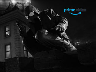 A figure in a dark outfit and goggles crouches on a ledge at night. A building and a billboard are in the background, creating a mysterious mood.