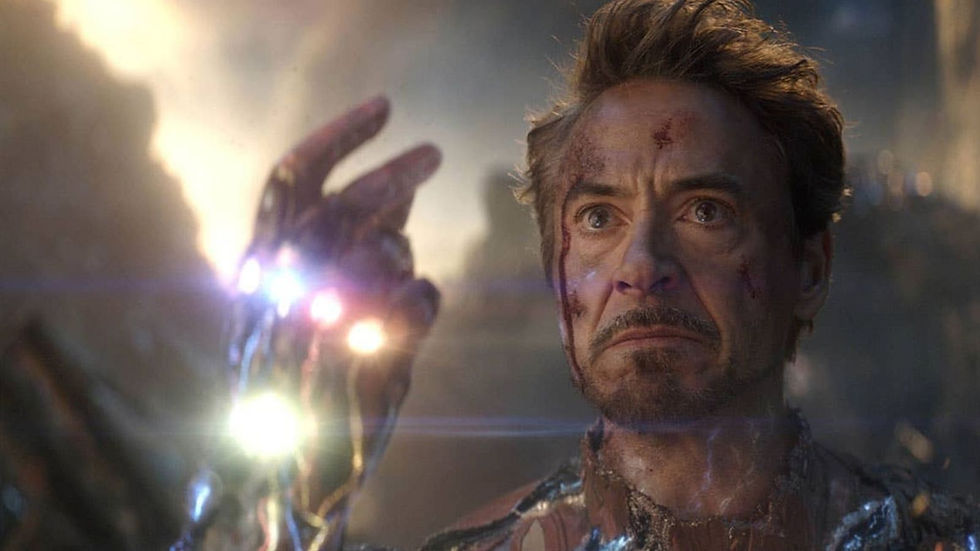 Injured man in a glowing gauntlet stares intensely in a smoky battle scene, face bloodied and determined.