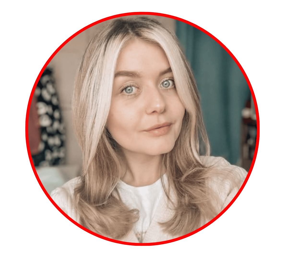 Blonde woman with blue eyes in a red circle portrait, neutral expression, indoors against a blurred background.