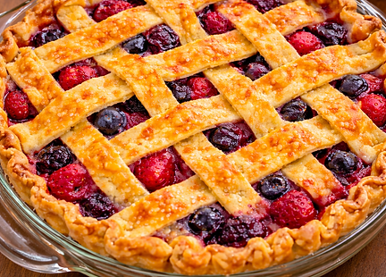 Five-fruit lattice pie baked in a glass pie dish with golden crust and bubbling berry filling.
