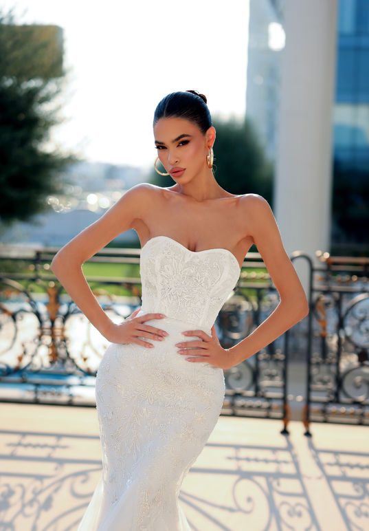 This stunning gown features a sweetheart neckline and a hip-hugging design that accentuates your curves. The sequinned floral motifs on the fishtail tulle skirt add a touch of glamour to your look, making it perfect for any bride looking to enhance and show off their figure. With its elegant and sophisticated style, this gown is sure to turn heads.