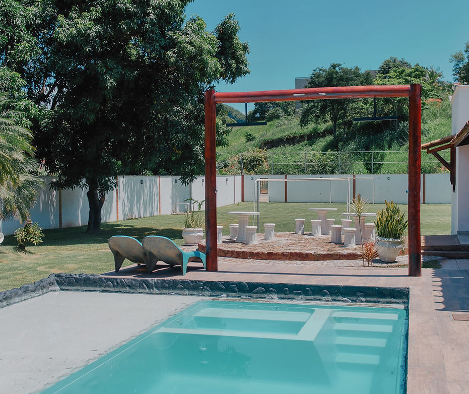Piscina, com vista para gramado verde e céu azul
