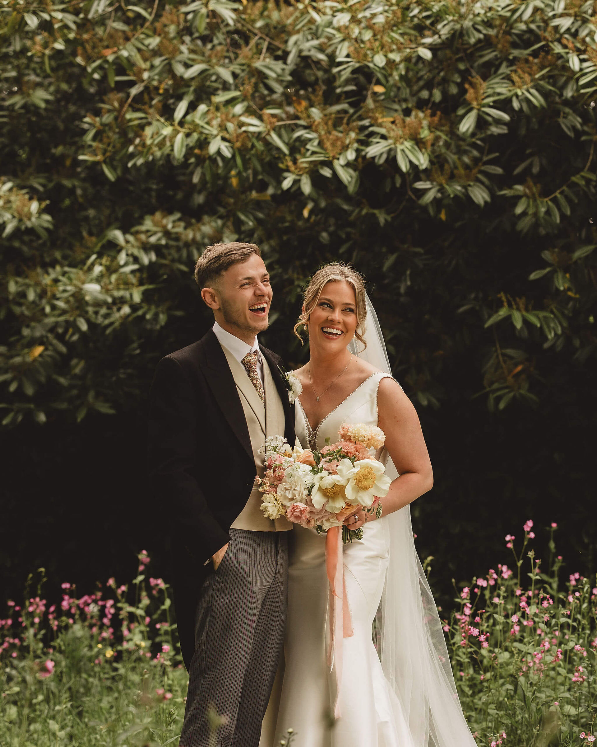 a joyful groom and his bride holding a beautiful bridal bouquet