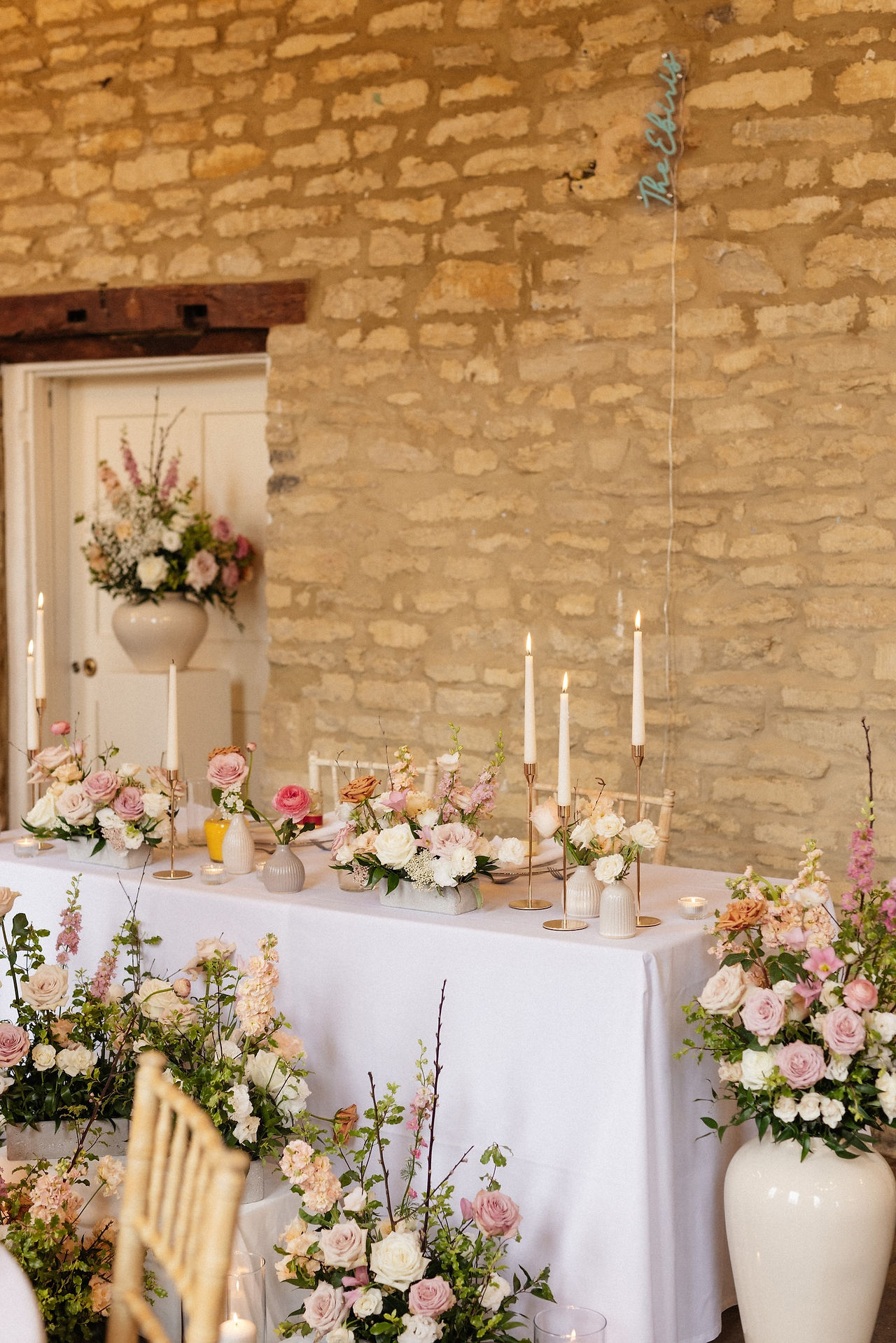Modern, abundant sweetheart table flower decor at the Great Hall at Hinwick House