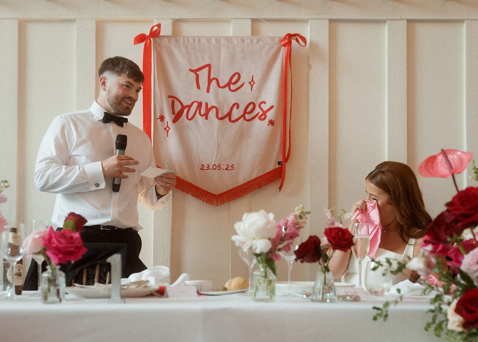 bride and groom at their top table surrounded by bold and romantic pink and red wedding flowers