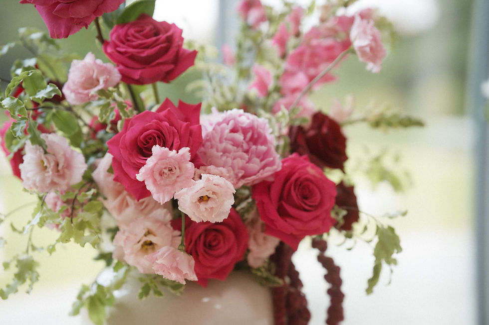 romantic, bold, stylish, pink and red wedding flowers in a modern off-white ceramic vase