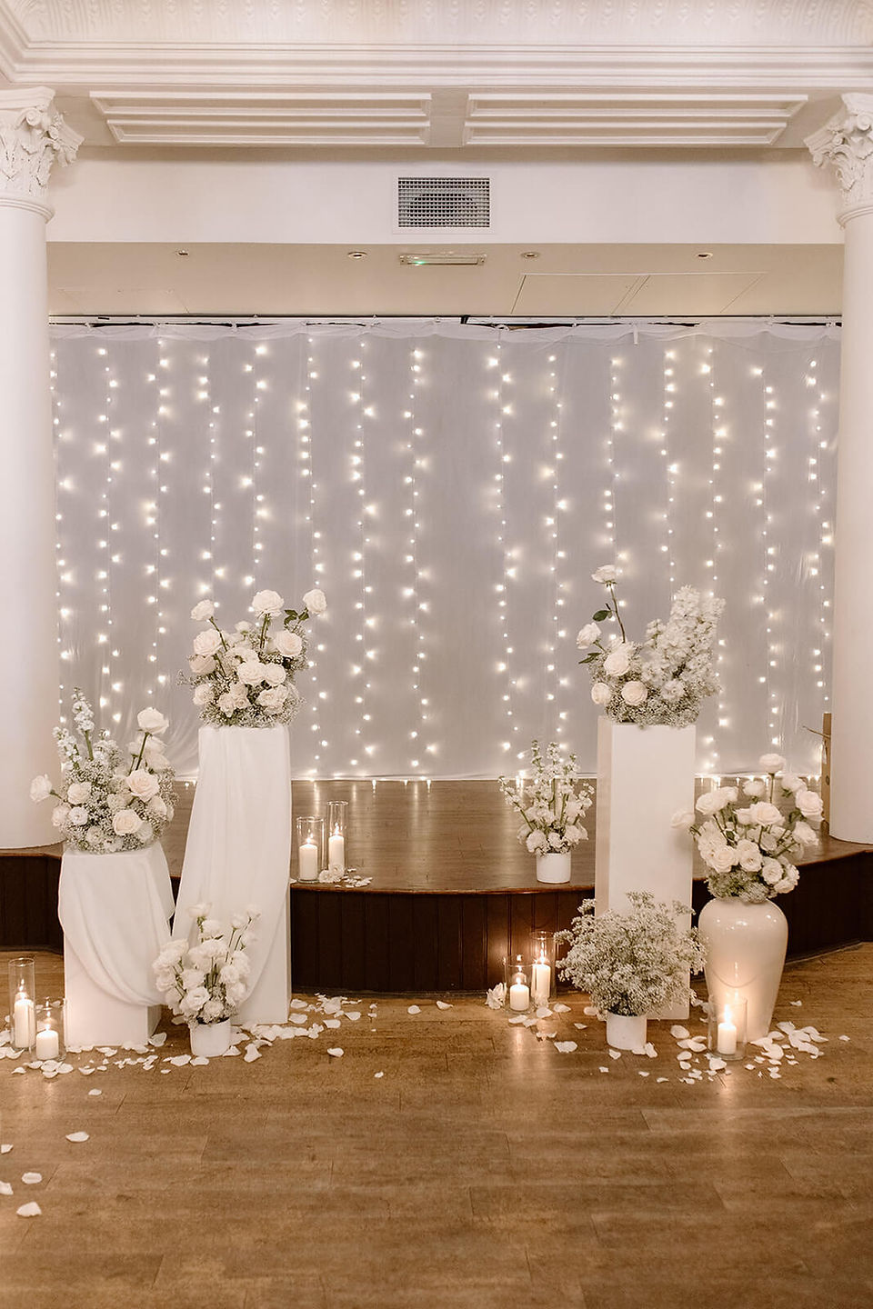 Textural white wedding ceremony flowers on modern white plinths