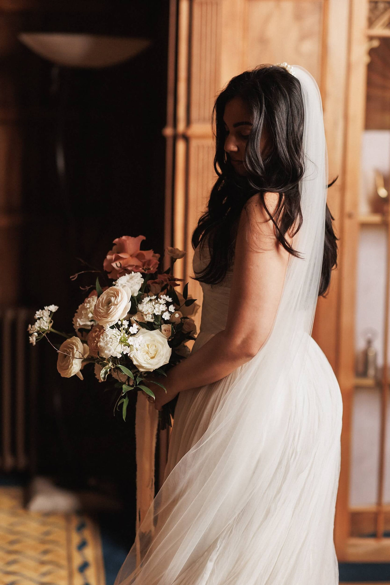 Beautiful bride holding her modern bridal bouquet in earthy colour palette