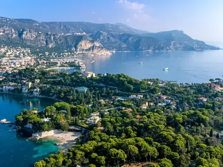 Scenic aerial view of the lush coastline, private villas, and clear blue bays of Saint-Jean-Cap-Ferrat in the South of France.