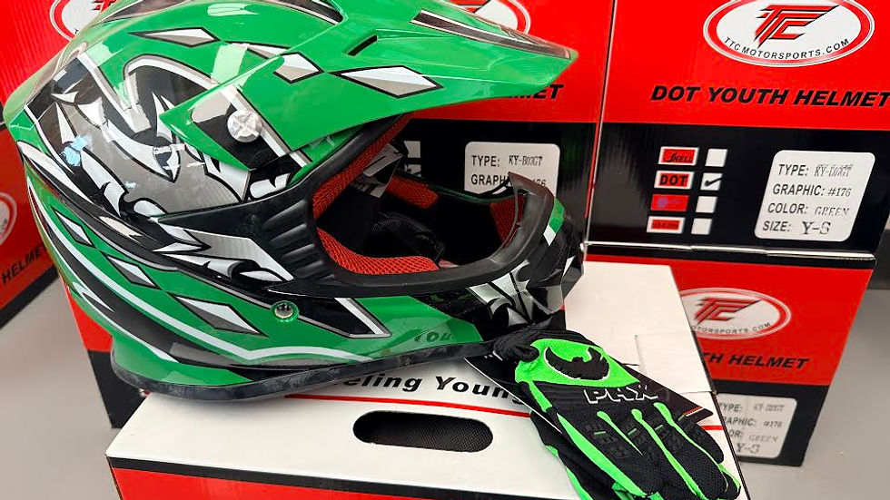 Green and black motocross helmet with matching gloves displayed on a white box. Red TC Motorsports boxes in the background show specs.