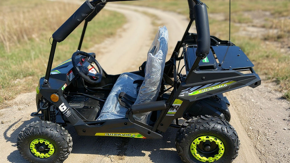 A small off-road buggy with bright green rims sits on a dirt path surrounded by grass, with clear skies. Plastic covers the seat.