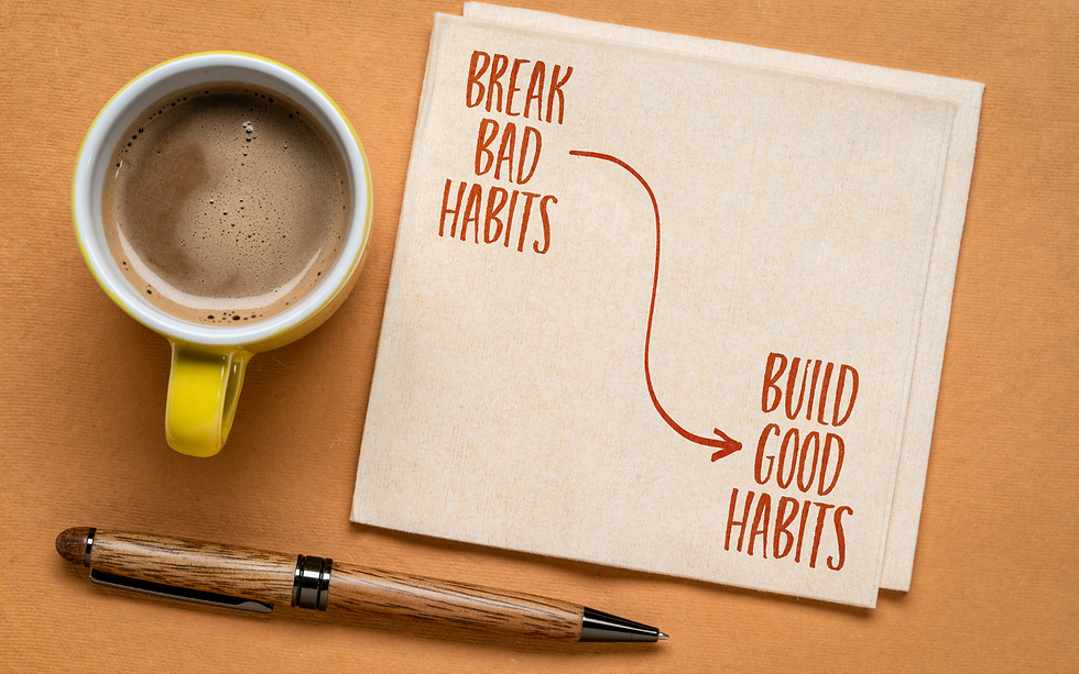 A yellow mug of coffee sits next to a piece of paper with the words "Break Bad Habits" and "Build Good Habits"