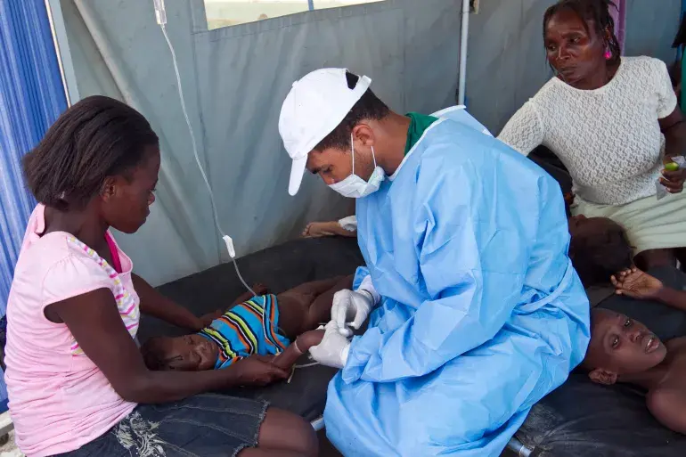 A cholera patient is treated with an IV solution administered by a Cuban doctor at a hospital in L'Estere, Haiti, on October 26, 2010 [Sophia Paris/Minustah via Getty Images] Credit: AlJazeera