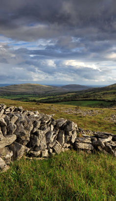 A stone wall in the Burren, and a wide view of the landscape